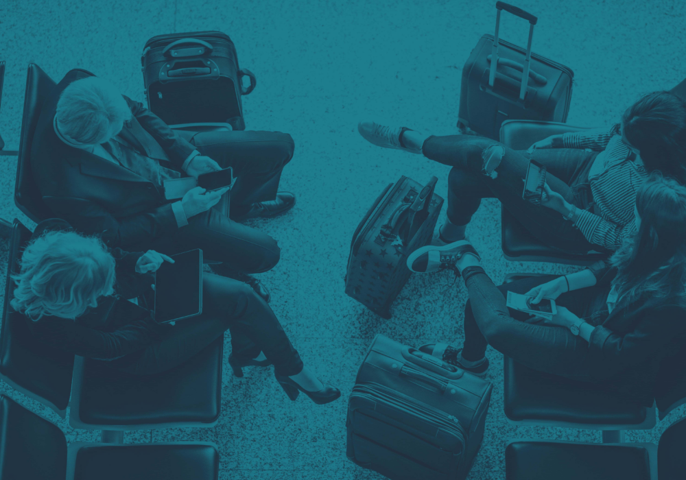 Passengers waiting with luggage at Jersey airport, highlighting the need for comprehensive travel insurance by Hepburns.